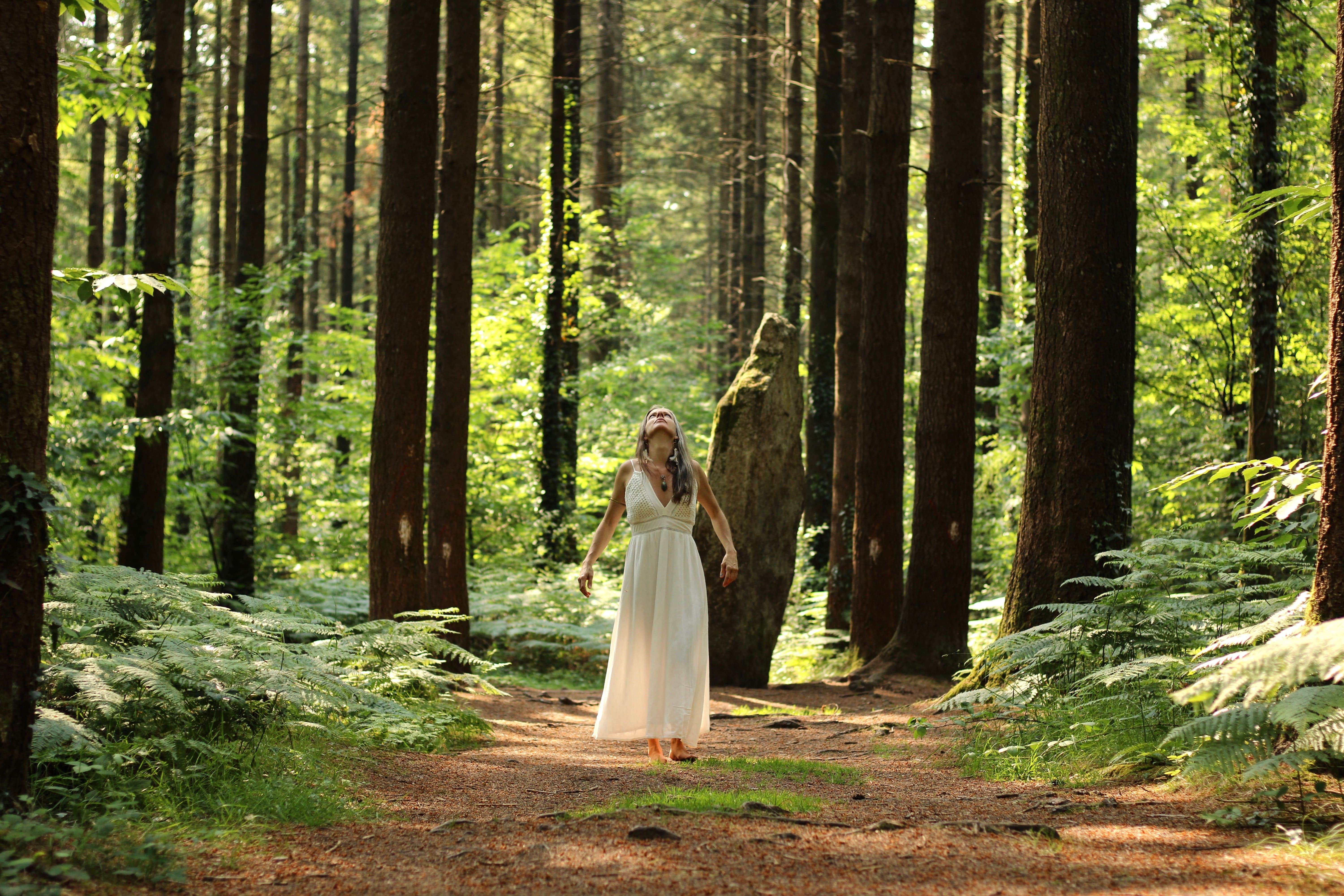 Cécilia près d'un menhir au milieu des bois